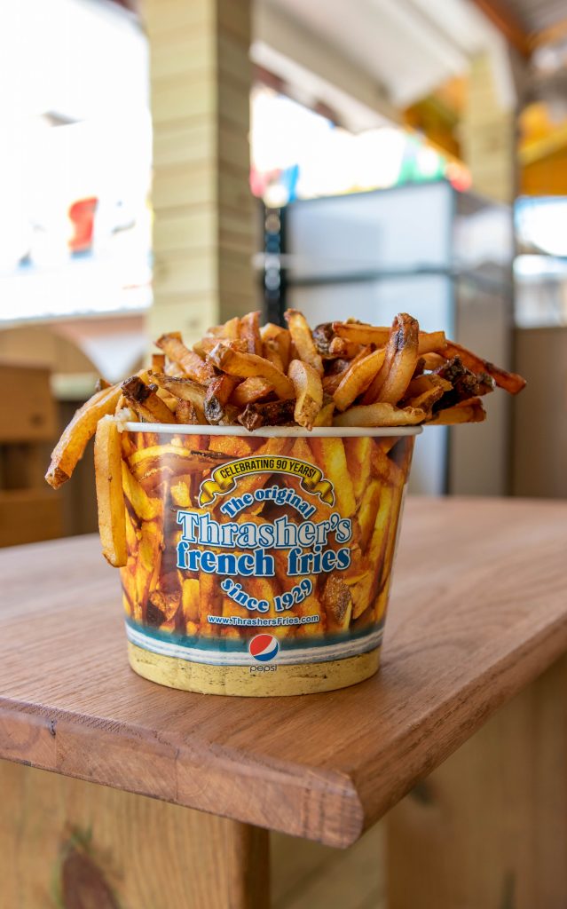 Thrasher's Fries bucket on a wooden table